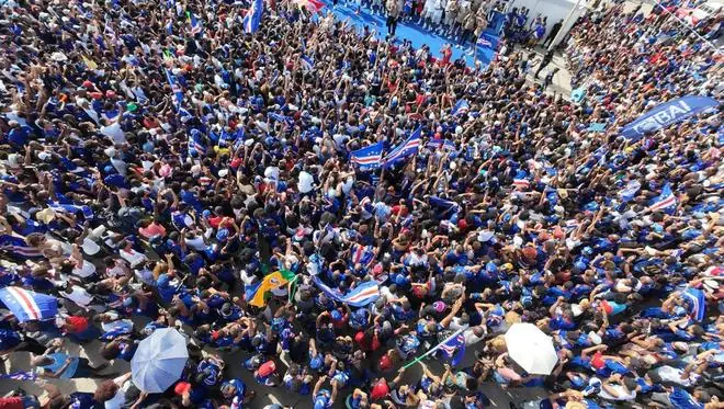 佛得角球员凯旋归国，乘货车拉横幅游行庆祝，在佛华人：机场周边围满了人，队员们在临时舞台给球迷签名